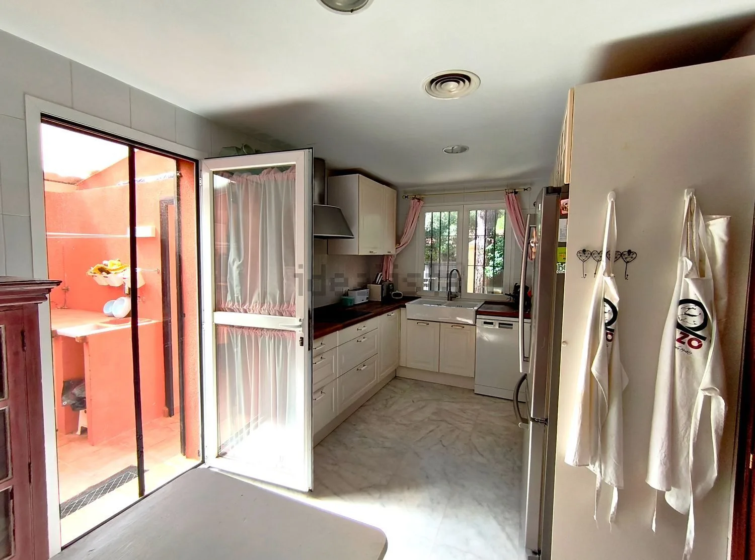 Cocina de la vivienda de Jara con ventana y salida al lavadero exterior.