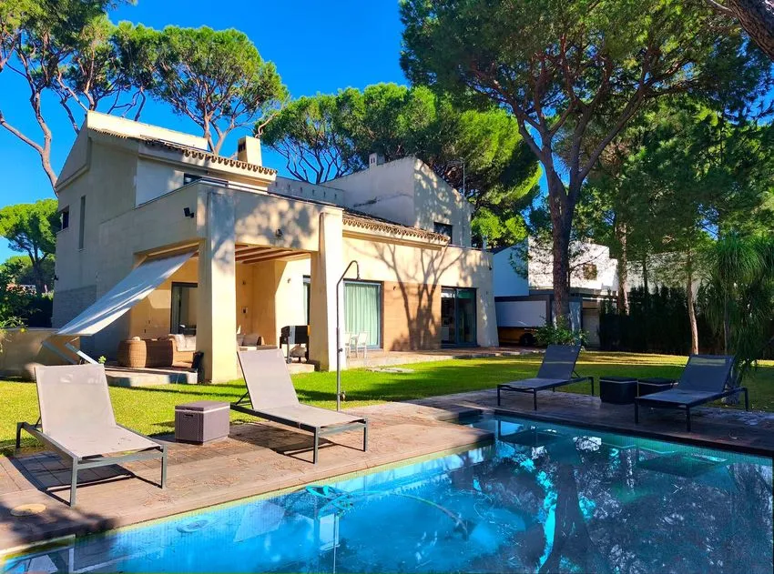 Piscina, jardín y fachada de la casa en la calle Acebuche.